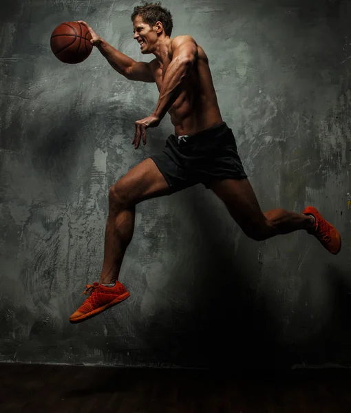 Мускулистый мужчина с баскетбольным мячом . — стоковое фото