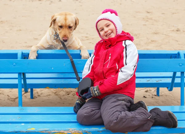 Liten flicka possing med en hund — Stockfoto