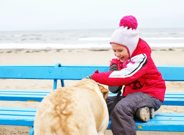 Bambina possedendo con un cane — Foto Stock