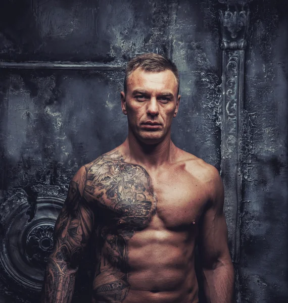 Сильный мускулистый мужчина с татуировками — стоковое фото