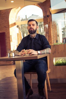 Bir kafede oturan Tattoed adam