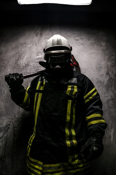 Firefighter in uniform on grey background