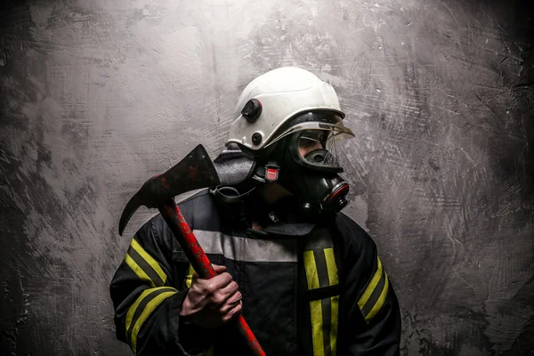 Bombero en uniforme sobre fondo gris — Foto de Stock