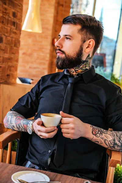 Hombre tatuado sentado en un café — Foto de Stock