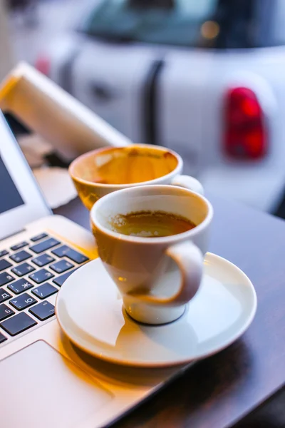 Portátil y taza de café en una mesa — Foto de Stock