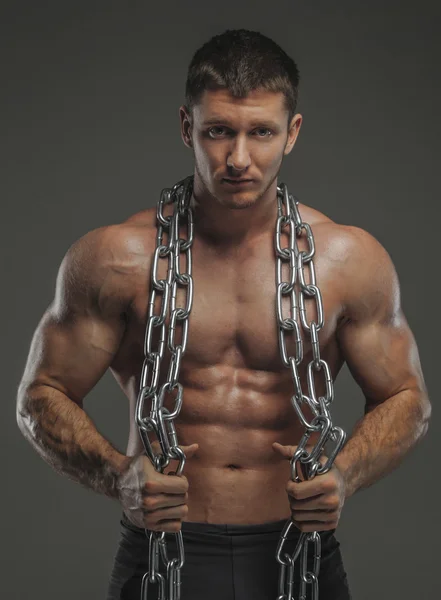 Muscular male holds chain — Stock Photo, Image
