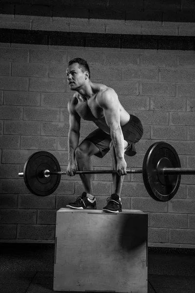 Man met naakte torso houdt barbell — Stockfoto