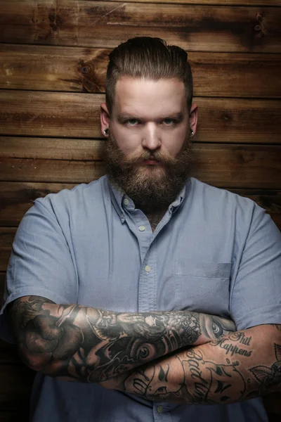 Man met tatoeage op wapens in studio — Stockfoto