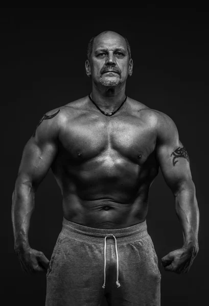 Muskulöser Mann mittleren Alters zeigt seine Muskeln — Stockfoto