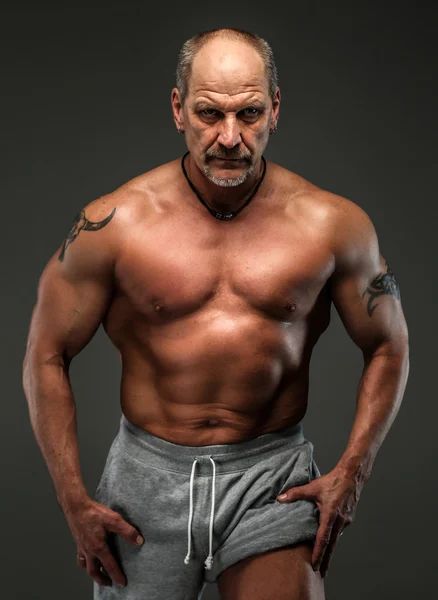 Muskulöser Mann mittleren Alters zeigt seine Muskeln — Stockfoto