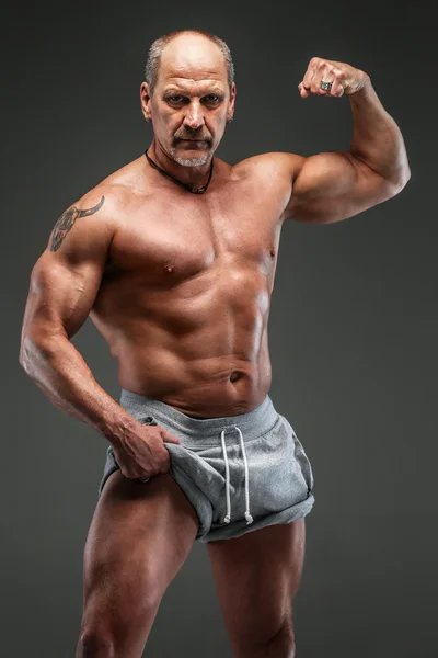 Hombre musculoso de mediana edad mostrando sus músculos — Foto de Stock