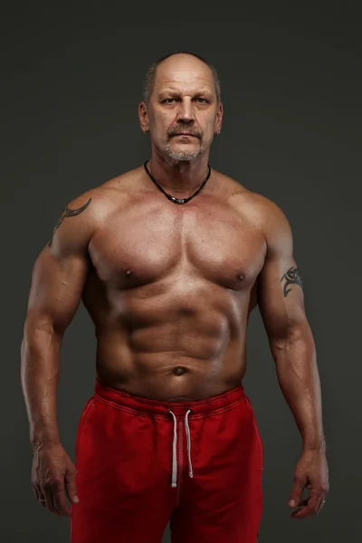 Muscular homem de meia idade mostrando seus músculos — Fotografia de Stock