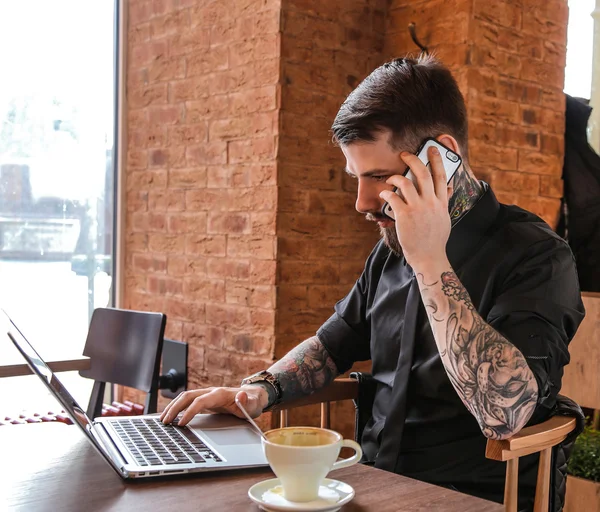 Man met tatoeage bellen door smartphone. — Stockfoto