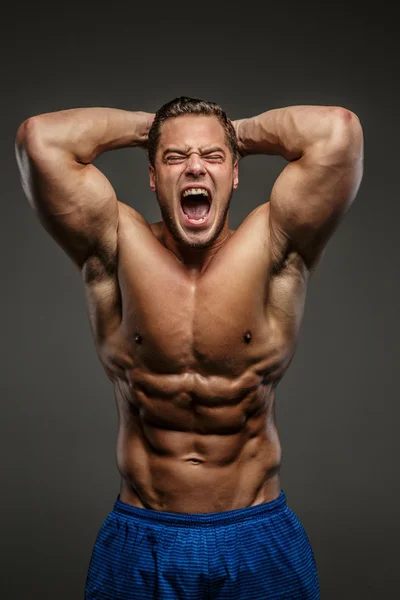 Awesome muscular guy on grey background — Stock Photo, Image