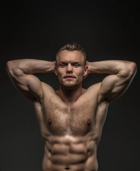 Homem muscular posando em estúdio em fundo cinza — Fotografia de Stock