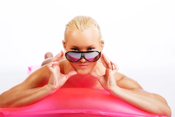 Atractiva mujer rubia acostada en un colchón de agua —  Fotos de Stock