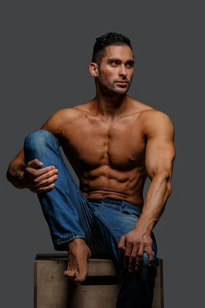 Мускулистый парень в синих джинсах — стоковое фото