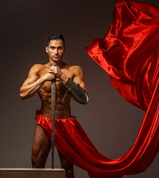 Muscular guy holding sword — Stock Photo, Image