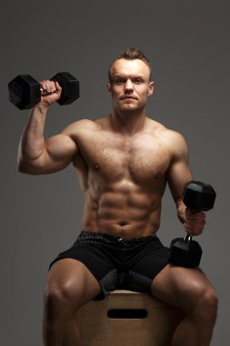Gömleksiz kaslı adam dumbells ile