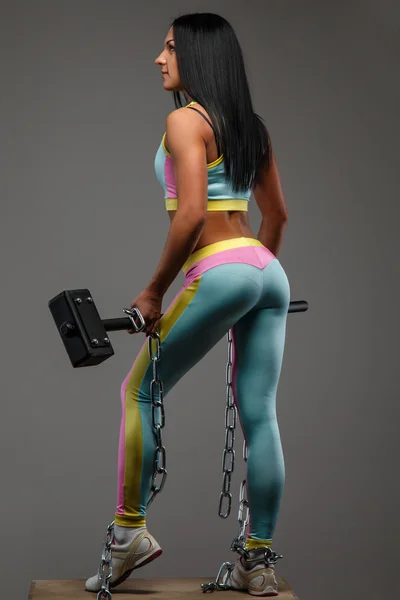 Женщина в разноцветной спортивной одежде с хаммером — стоковое фото