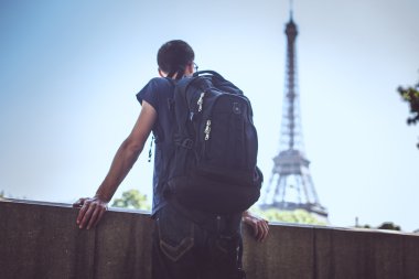 Turist Eyfel Kulesi arka plan üzerinde bir çanta.