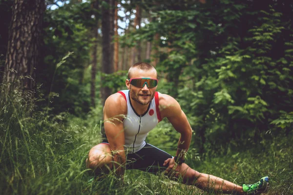 Hombre de fitness haciendo ejercicios sobre la naturaleza . — Foto de Stock