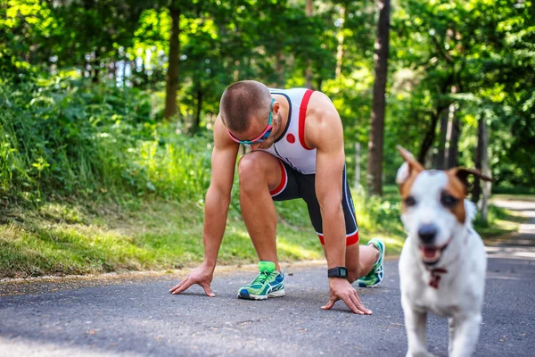 Deportista con su perro en el bosque . — Foto de Stock