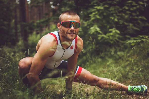 Hombre en ropa deportiva haciendo extensión de cuerpo — Foto de Stock