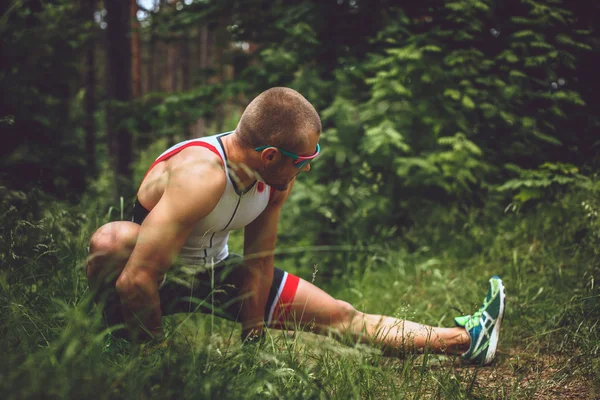 Hombre en ropa deportiva haciendo extensión de cuerpo — Foto de Stock