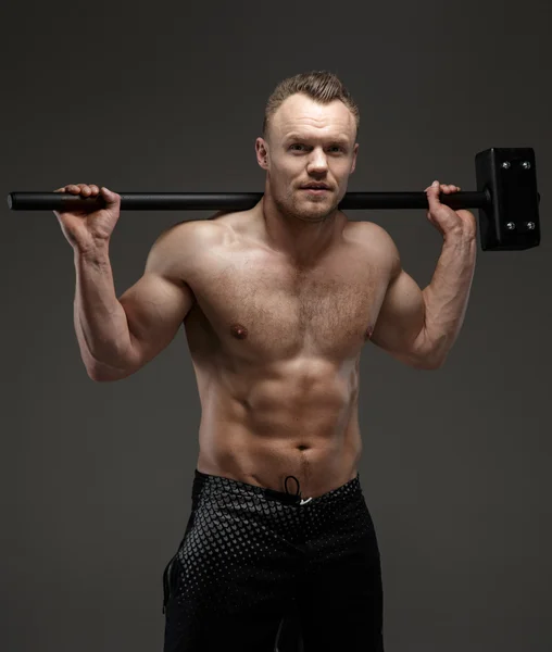 Muscular shirtless guy holding big hummer — Stock Photo, Image