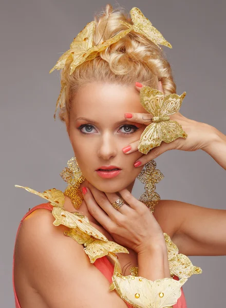 Blondes Weibchen mit goldenem Schmetterling. — Stockfoto