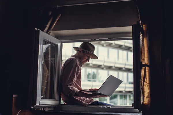 Guy in big hat sitting in the window — Stock Photo, Image