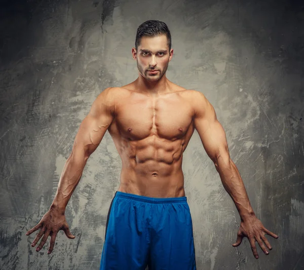 Fitness man in blue shorts posing — Stockfoto