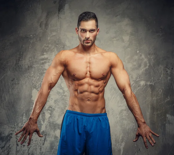 Hombre de fitness en pantalones cortos azules posando — Foto de Stock