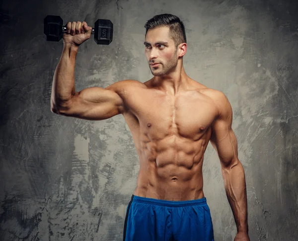 Muscular guy holding dumbell — Stok fotoğraf