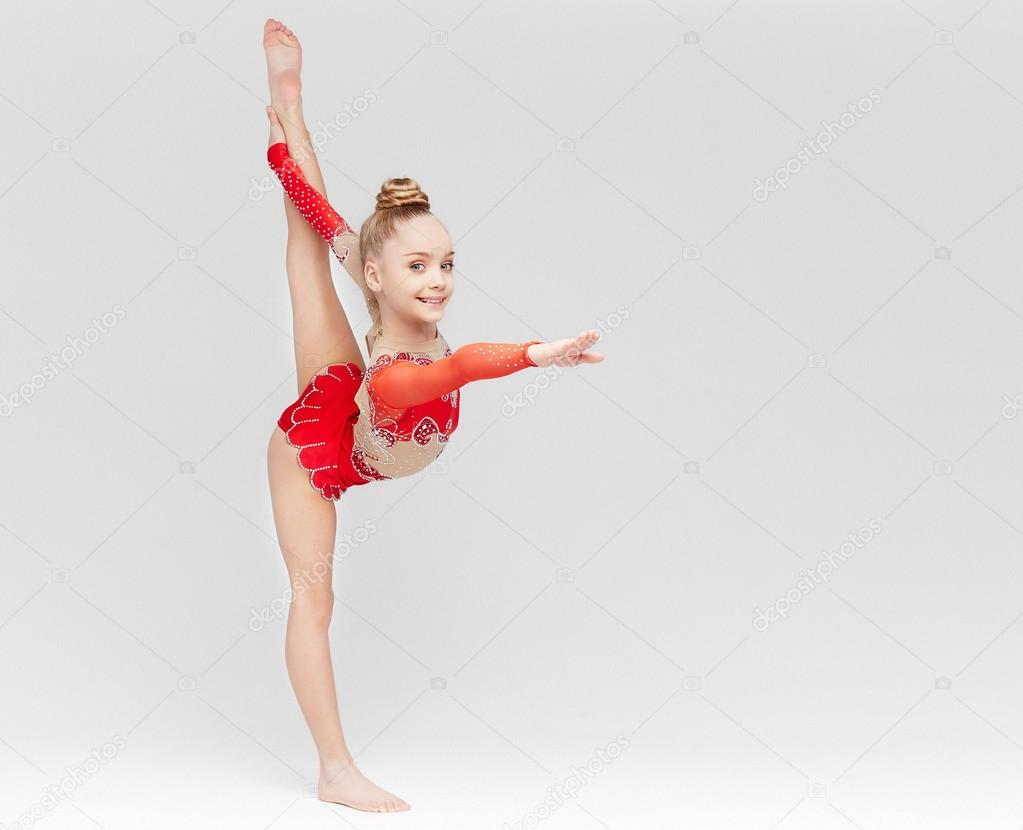 Teenage girl in red dress doing gymnastic exercises 