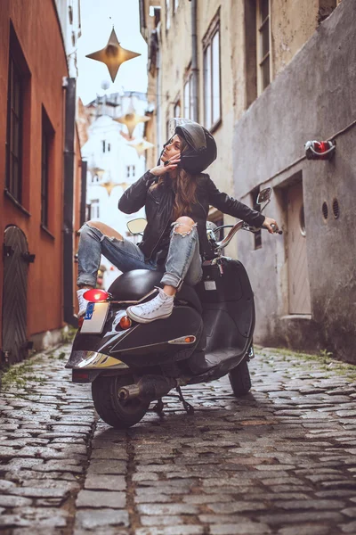 Aantrekkelijke slanke vrouw zittend op scooter — Stockfoto