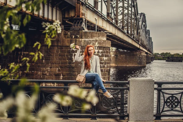 Rödhårig casual flicka poserar nära big river. — Stockfoto