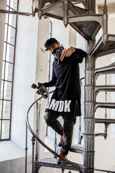 Man in het masker houden skateboard. — Stockfoto