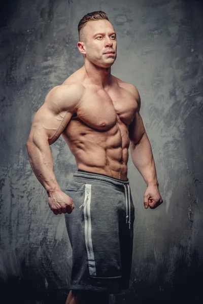 Big muscular man in grey shorts — Stock Photo, Image