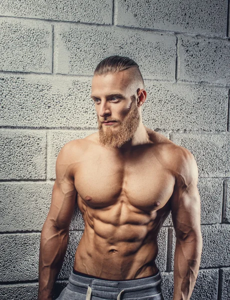 Homem musculoso com barba mostrando seu grande corpo . — Fotografia de Stock