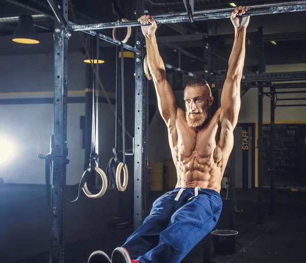 Uomo muscoloso senza maglietta in pantaloni sportivi blu . — Foto Stock