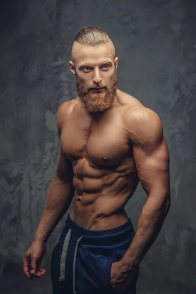 Homem musculoso com barba mostrando seu grande corpo . — Fotografia de Stock