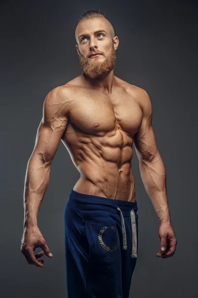 Gespierde man met baard tonen zijn grote lichaam. — Stockfoto