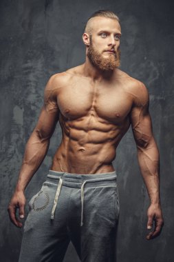 Sakallı gömleksiz vücut geliştirmeci.