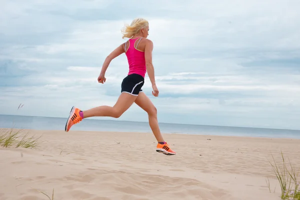 Hoppande blond kvinna i sommar sportkläder. — Stockfoto
