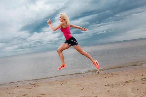 Jumping blond woman in summer sportswear. — Stock Photo, Image