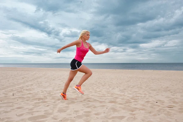 运动型的金发美女在沙滩上运行 — 图库照片