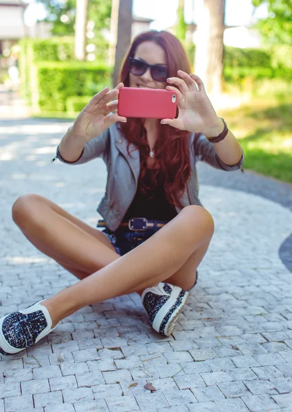 Жінка тримає рожевий смартфон . — стокове фото