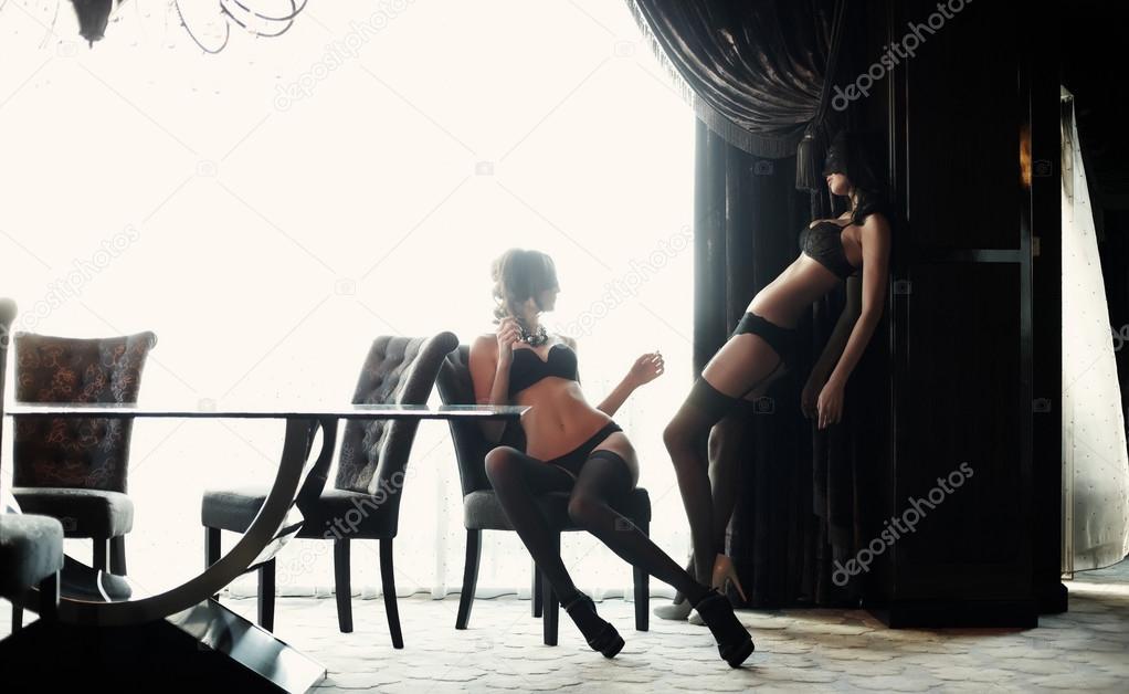 Two women in masks and black underwear